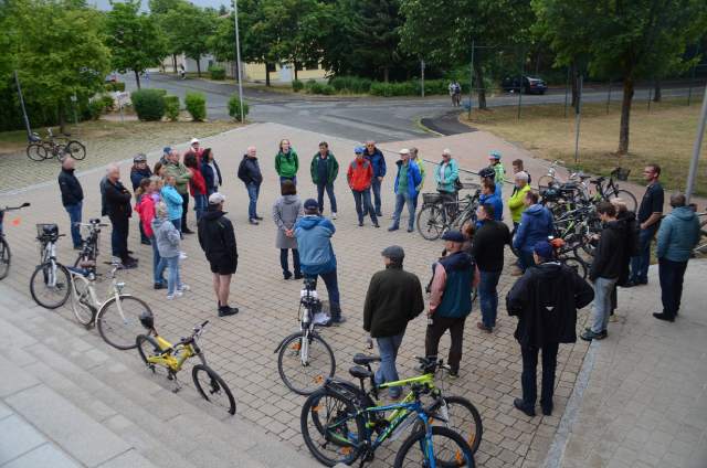 Menschen vor der Sportarena mit ihren Fahrrädern