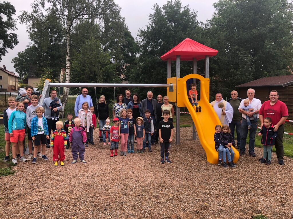 Alle Besucher der Eineweihung des Spielplatzes Guttenthau stehen vor und auf dem Rutschen- und Schaukelgerüst