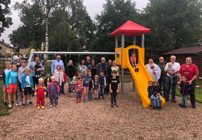 Alle Besucher der Eineweihung des Spielplatzes Guttenthau stehen vor und auf dem Rutschen- und Schaukelgerüst