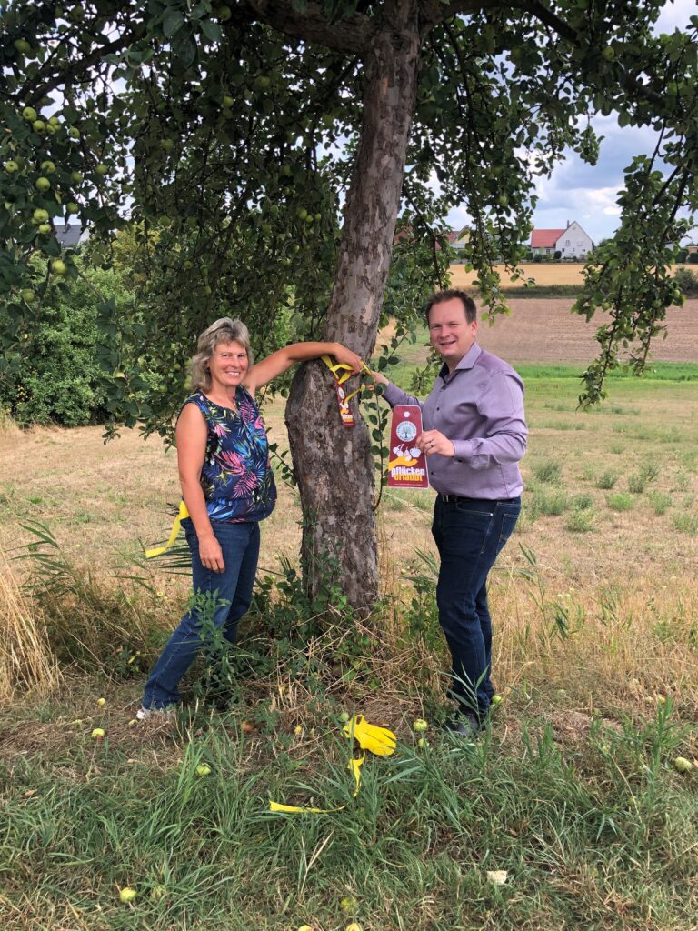 Barbara Dahinten vom LPV und Christian Porsch legen ein gelebes Band an einem Baum an