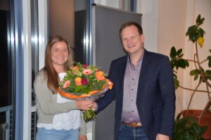 Bürgermeister Christian Porsch übergibt Romy Christl eine Blumenstrauß