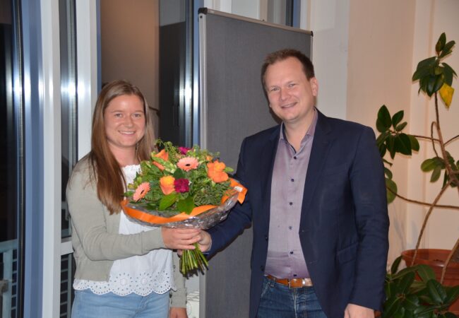 Bürgermeister Christian Porsch übergibt Romy Christl eine Blumenstrauß