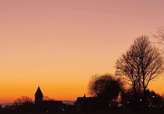 Sonnenuntergang mit der Aufschrift "Gemeindebrief März 2023"